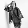 Knitted poncho with sleeves and fringes