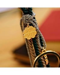 Lucky charm with enamel pomegranate and satin cords Lucky charm with enamel pomegranate and satin cords