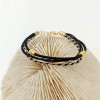 Handmade bracelet made of cotton cords with gold-plated metal parts