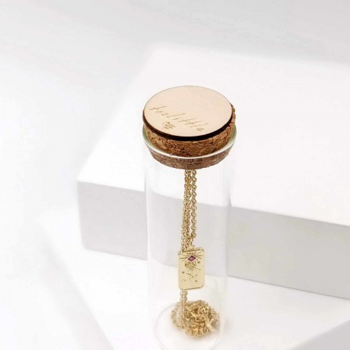 Short gold-plated necklace with zircon in a glass bottle
